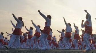 Ribuan peserta melakukan senam poco-poco saat pemecahan rekor dunia Guinness World Records  di Monas, Jakarta, Minggu (5/8). Kegiatan tersebut dalam rangka menyambut Asian Games 2018 itu diikuti 65 ribu peserta dari berbagai kalangan. [suara.com/Muhaimin A Untung]