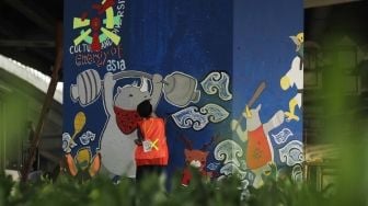 Pelukis membuat mural saat kompetisi mural Citra Marga Nusaphala Persada (CMNP) di sepanjang Jl Layang Tol Rawamangun - Pulogadung, Jakarta, Minggu (5/8). Sebanyak 73 Tiang tol dilukis oleh 200 seniman dari berbagai daerah di Indonesia untuk berpartisipasi dalam ajang kompetisi melukis mural dengan tema Asian Games dan HUT Kemerdekaan Indonesia. [suara.com/Muhaimin A Untung]