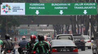 Kendaraan meintas di bawah marka jalan elektronik di Jalan Sudirman, Jakarta, Selasa (7/8). [suara.com/Oke Atmaja]