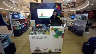 Sales promotion girl (SPG)  menjaga di booth merchandise Asian Games 2018 di Senayan City, Jakarta,  Rabu (8/8). Penjualan merchandise dengan harga Rp10.000 sampai Rp4.000.000 itu dapat menyukseskan perhelatan Asian Games 2018. [Suara.com/Oke Atmaja]