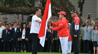 Presiden Joko Widodo (kiri) menyerahkan bendera Merah Putih kepada Ketua Komite Olahraga Indonesia (KOI) Erick Thohir (tengah) disaksikan CdM kontingen Indonesia, Komjen Pol Syafruddin saat upacara pelepasan di halaman tengah Kompleks Istana, Jakarta, Rabu (8/8). ANTARA FOTO/Wahyu Putro A