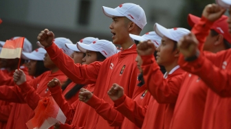 Atlet dan ofisial mengepalkan tangan ketika mengikuti upacara pelepasan kontingen Asian Games 2018 di halaman tengah Kompleks Istana, Jakarta, Rabu (8/8). ANTARA FOTO/Wahyu Putro A