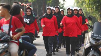 Sejumalah warga mengikuti lomba gerak jalan di kelurahan Kelapa Dua Wetan, Jakarta Timur, Minggu (12/8). Perlombaan tersebut untuk menyambut HUT ke-73 RI. [Suara.com/Muhaimin A Untung]