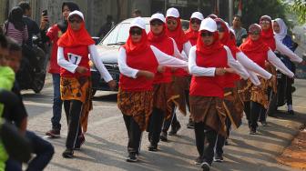 Sejumalah warga mengikuti lomba gerak jalan di kelurahan Kelapa Dua Wetan, Jakarta Timur, Minggu (12/8). Perlombaan tersebut untuk menyambut HUT ke-73 RI. [Suara.com/Muhaimin A Untung]