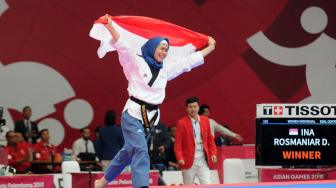 Atlet taekwondo putri Indonesia, Defia Rosmaniar melakukan victory lap usai memenang nomor poomsae tunggal putri taekwondo di Asian Games 2018 di Jakarta Convention Center (JCC), Minggu (19/8) ANTARA FOTO/INASGOC/Sunyoto