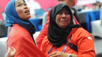 Atlet putri taekwondo Indonesia, Defia Rosmaniar disambut pelatih kepala Rahmi Kurnia yang menangis setelah anak asuhnya meraih medali emas tunggal putri poomsae pada Asian Games 2018 di Jakarta Convention Center (JCC), Minggu (19/8). ANTARA FOTO/INASGOC/Sunyoto