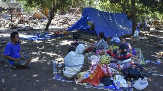 Sejumlah warga beristirahat dekat rumahnya yang roboh pascagempa di Dusun Labuan Pandan, Desa Padak Guar, Kecamatan Sambelia, Lombok Timur, NTB, Senin (20/8). ANTARA FOTO/Ahmad Subaidi