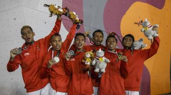 Regu panjat tebing Indonesia menunjukkan medali setelah menang pada final speed relay putra Asian Games 2018 di Arena Panjat Tebing Jakabaring Sport City, Palembang, Sumatera Selatan, Senin (27/8). ANTARA FOTO/INASGOC/Hendra Nurdiyansyah