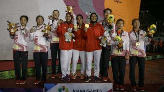 Regu panjat tebing Indonesia dan Cina menunjukkan medali setelah penganugerahan pemenang final speed relay putri Asian Games 2018 di Arena Panjat Tebing Jakabaring Sport City, Palembang, Sumatera Selatan, Senin (27/8). ANTARA FOTO/INASGOC/Hendra Nurdiyansyah