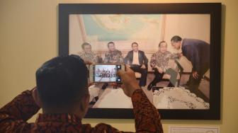 Pengunjung melihat foto pameran foto jurnalistik Warna-Warni Parlemen Moderen di Gedung Parlemen, Jakarta, Kamis (30/8). [Suara.com/Muhaimin A Untung]