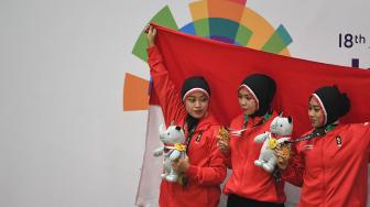 Tim silat Indonesia peraih medali emas Pramudita Yuristya (kiri), Lutfi Nurhasanah (tengah) dan Gina Tri Lestari (kanan) berpose usai upacara penyerahan medali nomor beregu putri pencak silat seni Asian Games 2018 di Padepokan Pencak Silat Taman Mini Indonesia Indah (TMII), Jakarta, Rabu (29/8). ANTARA FOTO/INASGOC/Melvinas Priananda