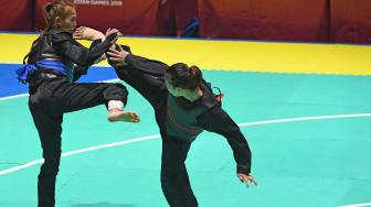 Pesilat Indonesia Wewey Wita (kanan) bertanding melawan pesilat Thailand Suda Lueangaphichatkun (kiri) dalam babak perempat final Kelas B Putri Asian Games 2018 di Padepokan Pencak Silat Taman Mini Indonesia Indah (TMII), Jakarta, Jumat (24/8). ANTARA FOTO/INASGOC/Melvinas Priananda