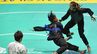 Pesilat Indonesia Wewey Wita (kanan) bertanding melawan pesilat Thailand Suda Lueangaphichatkun (kiri) dalam babak perempat final Kelas B Putri Asian Games 2018 di Padepokan Pencak Silat Taman Mini Indonesia Indah (TMII), Jakarta, Jumat (24/8). ANTARA FOTO/INASGOC/Melvinas Priananda