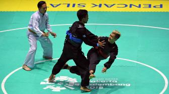 Pesilat Indonesia Hanifah Yudani Kusumah (kanan) menyerang pesilat Thailand Adilan Chemaeng (kanan) dalam babak semifinal Kelas C Putra Asian Games 2018 di Padepokan Pencak Silat Taman Mini Indonesia Indah (TMII), Jakarta, Minggu (26/8). ANTARA FOTO/INASGOC/Melvinas Priananda