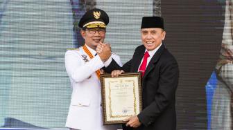 Gubernur Jawa Barat Ridwan Kamil (kiri) menyerahkan piagam ucapan terima kasih kepada Penjabat Gubernur Jabar M Iriawan (kanan) saat acara Sertijab Gubernur Jawa Barat di Gedung Sate, Bandung, Jawa Barat