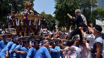 Sejumlah peserta mengangkat arak-arakan mikoshi saat Festival Budaya Pop Jak-Japan Matsuri 2018, di Gelora Bung Karno Senayan, Jakarta, Minggu (9/9). festival tersebut mengusung tema "Indonesia and Japan Always Together", dan dimeriahkan dengan parade mikoshi, cosplay japan, JKT 48 dan AKB 48. [Suara.com/Muhaimin A Untung]