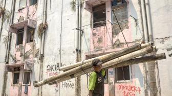 Pekerja mengangkat sisa bangunan saat pembongkaran Rumah Susun Karang Anyar,  Jakarta