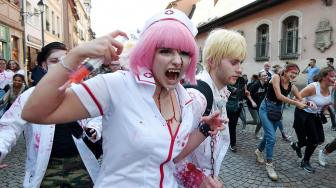 Warga memakai kostum dan berdandan menyerupai zombie saat acara Zombie Walk di kota Strasbourg, Prancis, Sabtu (15/9/2018). [AFP/FREDERICK]