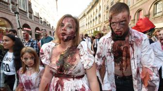 Warga memakai kostum dan berdandan menyerupai zombie saat acara Zombie Walk di kota Strasbourg, Prancis, Sabtu (15/9/2018). [AFP/FREDERICK]