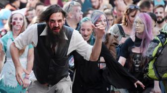 Warga memakai kostum dan berdandan menyerupai zombie saat acara Zombie Walk di kota Strasbourg, Prancis, Sabtu (15/9/2018). [AFP/FREDERICK]