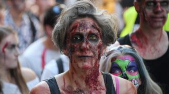 Warga memakai kostum dan berdandan menyerupai zombie saat acara Zombie Walk di kota Strasbourg, Prancis, Sabtu (15/9/2018). [AFP/FREDERICK]