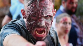 Warga memakai kostum dan berdandan menyerupai zombie saat acara Zombie Walk di kota Strasbourg, Prancis, Sabtu (15/9/2018). [AFP/FREDERICK]