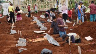 Warga memakamkan kembali jenazah keluarga mereka saat dilakukan pembongkaran makam di TPU Kumpi Saribah, Limo, Depok, Jawa Barat, Rabu (19/9). [ ANTARA FOTO/Indrianto Eko Suwarso ]