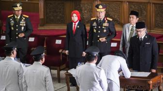 Gubernur Jawa Barat Ridwan Kamil (kanan) menyaksikan penandatanganan berita acara Pengucapan Sumpah Jabatan dan Pakta Integritas Bupati dan Wali Kota di gedung Merdeka, Bandung, Jawa Barat, Kamis (20/9). [ANTARA FOTO/M Agung Rajasa]