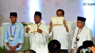 Calon Presiden dan Wapres Joko Widodo-Ma'ruf Amin dan Calon Presiden dan Wapres Prabowo Subianto-Sandiaga Uno  menunjukkan nomor urut Pemilu Presiden 2019 di Kantor KPU, Jakarta, Jumat (21/9). [Suara.com/Muhaimin A Untung]