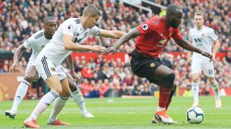 Striker Manchester United, Romelu Lukaku bersaing dengan gelandang  Wolverhampton Wanderers, Conor Coady selama pertandingan Manchester United melawan Wolverhampton Wanderers di Old Trafford di Manchester, Inggris, Sabtu (22/9). [AFP/Lindsey PARNABY]