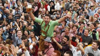 Para peserta mengangkat gelas bir saat pembukaan festival bir terbesar di dunia Oktoberfest ke-185 di Munich, Jerman, Sabtu (22/9). [AFP/Christof STACHE]
