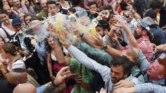 Para peserta mengangkat gelas bir saat pembukaan festival bir terbesar di dunia Oktoberfest ke-185 di Munich, Jerman, Sabtu (22/9). [AFP/Christof STACHE]
