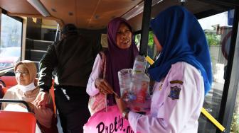 Warga membayar tiket dengan botol plastik bekos saat menumpang Bus Suroboyo di Surabaya, Jawa Timur, Selasa (25/9). [ANTARA FOTO/Zabur Karuru]