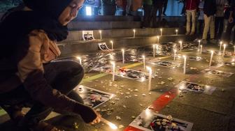 Seorang simpatisan yang tergabung dalam Bandung Supporter Alliance menyalakan lilin untuk korban meninggal karena sepak bola saat aksi solidaritas suporter di Bandung, Jawa Barat, Kamis (27/9). [ANTARA FOTO/M Agung Rajasa]