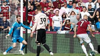 Penyerang  West Ham United Marko Arnautovic mencetak gol ketiga mereka usai melewati kiper Manchester United David de Gea saat pertandingan sepak bola Liga Inggris antara West Ham United melawan Manchester United di London Stadium, London, Inggris, Sabtu (29/9). [AFP/Ian KINGTON]
