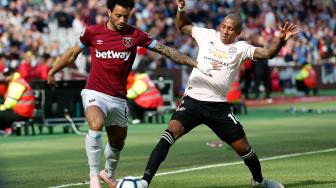 Ashley Young  berduel dengan gelandang West Ham United Felipe Anderson saat pertandingan sepak bola Liga Inggris antara West Ham United melawan Manchester United di London Stadium, London, Inggris, Sabtu (29/9). [AFP/Ian KINGTON]