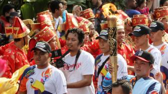 Suasana pawai obor Asian Para Games 2018 ketika melintas di kawasan Jalan Medan Merdeka Selatan, Jakarta, Minggu (30/9). [Suara.com/Oke Dwi Atmaja]