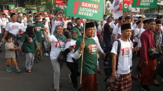 Sejumlah santri mengikuti jalan sehat sarungan di kawasan Monas, Jakarta, Minggu (30/9). [Suara.com/Oke Dwi Atmaja]