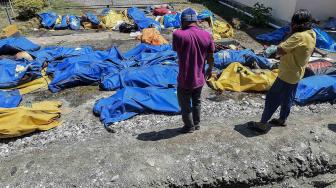 Warga mencari korban gempa dan tsunami yang tewas di RS Bhayangkara, Palu, Sulawesi Tengah, Minggu (30/9).[ANTARA FOTO/Muhammad Adimaja]