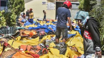 Warga mencari korban gempa dan tsunami yang tewas di RS Bhayangkara, Palu, Sulawesi Tengah, Minggu (30/9).[ANTARA FOTO/Muhammad Adimaja]