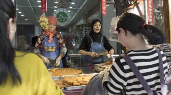 Seorang penjual melayani pembelinya yang menjual makanan halal di pasar Jalan Ben Yuan Men, kawasan komunitas muslim di Xi'an, Cina, Sabtu (29/9). [ANTARA FOTO/Hermanus Prihatna]
