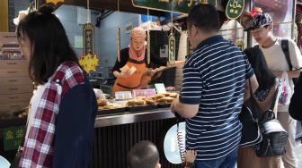 Seorang penjual melayani pembelinya yang menjual makanan halal di pasar Jalan Ben Yuan Men, kawasan komunitas muslim di Xi'an, Cina, Sabtu (29/9). [ANTARA FOTO/Hermanus Prihatna]
