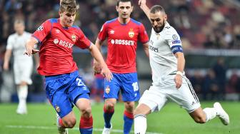 Pemain depan Real Madrid Karim Benzema berusaha melewati gelandang  CSKA Jaka Bijol selama pertandingan grup G Liga Champions antara CSKA Moskow  melawan Real Madrid di Stadion Luzhniki, Moskow, Selasa (2/9). [AFP/Mladen ANTONOV]