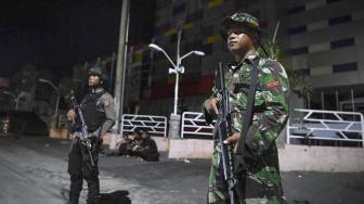 Personel TNI dan Polri berjaga di depan sebuah pusat perbelaanjan di Palu, Sulawesi Tengah, Selasa (2/10) malam. [ANTARA FOTO/Hafidz Mubarak]