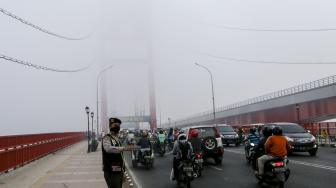 Sejumlah kendaraan melintas di atas jembatan Ampera yang tertutup kabut asap di Palembang, Sumatera Selatan, Jumat (5/10). [ANTARA FOTO/Nova Wahyudi]