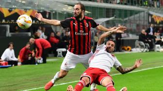 Pemain depan AC Milan Gonzalo Higuain dan gelandang Olympiakos Guilherme berebut bola selama pertandingan sepak bola Grup F Liga Europa antara AC Milan melawan Olympiakos di stadion San Siro, Milan, Italia, Kamis (4/9). [AFP/Miguel MEDINA]