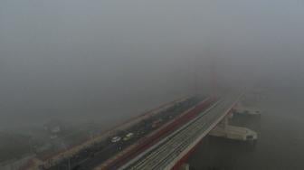 Sejumlah kendaraan melintas di atas jembatan Ampera yang tertutup kabut asap di Palembang, Sumatera Selatan, Jumat (5/10). [ANTARA FOTO/Nova Wahyudi]