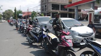 Anggota TNI berjaga di tengah antrean kendaraan di salah satu SPBU di Palu, Sulawesi Tengah, Sabtu (6/10). ANTARA FOTO/Basri Marzuki