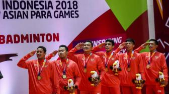 Tim bulu tangkis beregu putra Indonesia Asian Para Games 2018 memberi hormat bendera saat pemberian medali cabang olahraga para bulu tangkis Asian Para Games 2018 di Istora Senayan, Jakarta, Minggu (7/10).  [ ANTARA FOTO/Galih Pradipta]