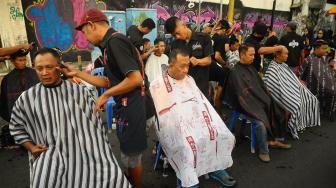 Sejumlah warga mencukur rambutnya pada acara cukur amal untuk gempa Palu dan Donggala di Kudus, Jawa Tengah, Minggu (7/10). [ANTARA FOTO/Yusuf Nugroho]